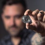 person holding silver bitcoin coin