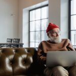 man in brown sweater using a laptop